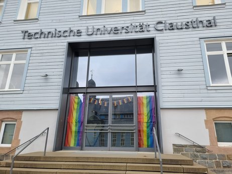 Hier ist das mit Regenbogen beflaggte TU Clausthal Hauptgebäude zu sehen.
