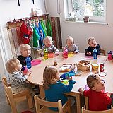 Kinder sitzen um einen Tisch